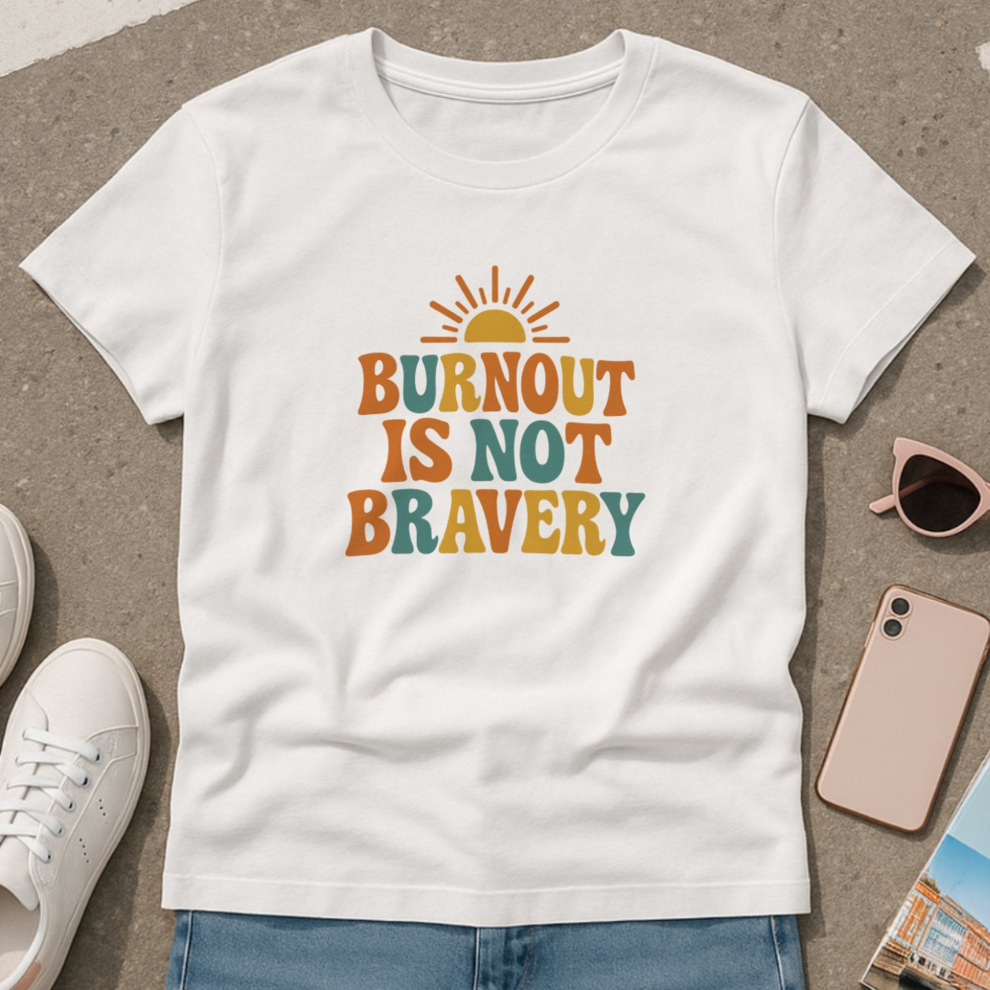 White mental health awareness t-shirt with retro-style typography and sun graphic saying “Burnout Is Not Bravery,” promoting rest, boundaries, and emotional wellbeing