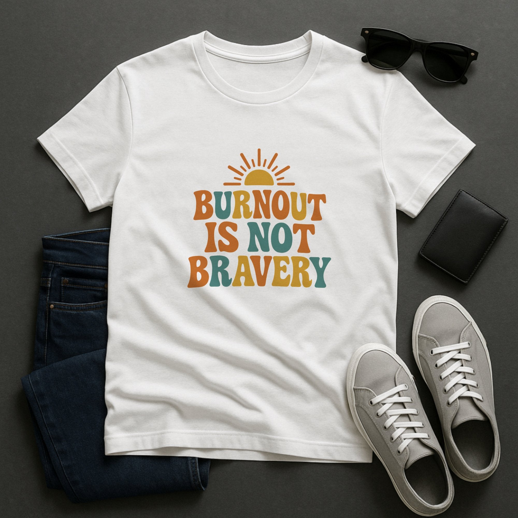 White mental health awareness t-shirt with retro-style typography and sun graphic saying “Burnout Is Not Bravery,” promoting rest, boundaries, and emotional wellbeing