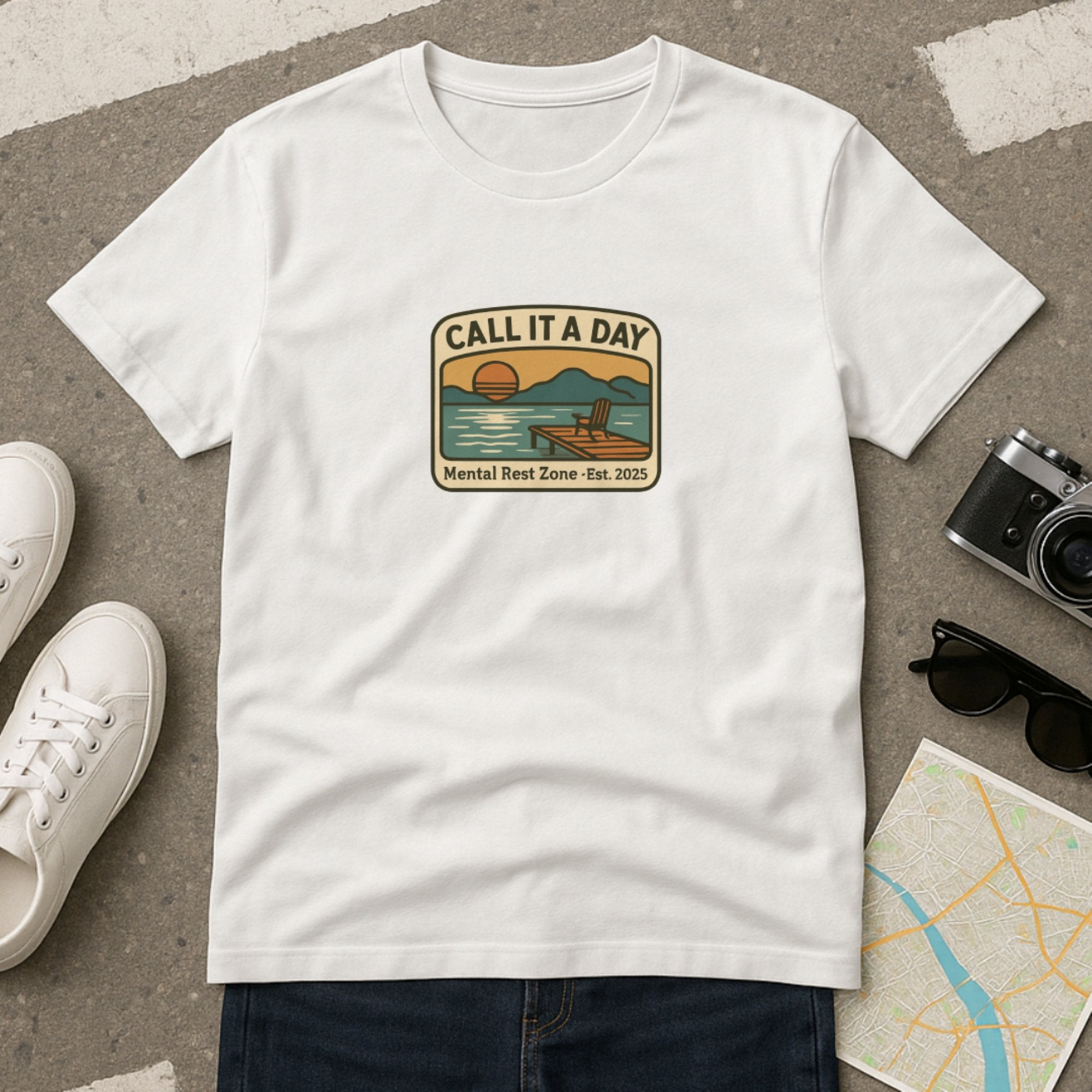 White “Call It a Day – Mental Rest Zone” t-shirt featuring a peaceful lakeside sunset with a lounge chair and calm water, reminding you to pause, breathe, and take a well-deserved mental break