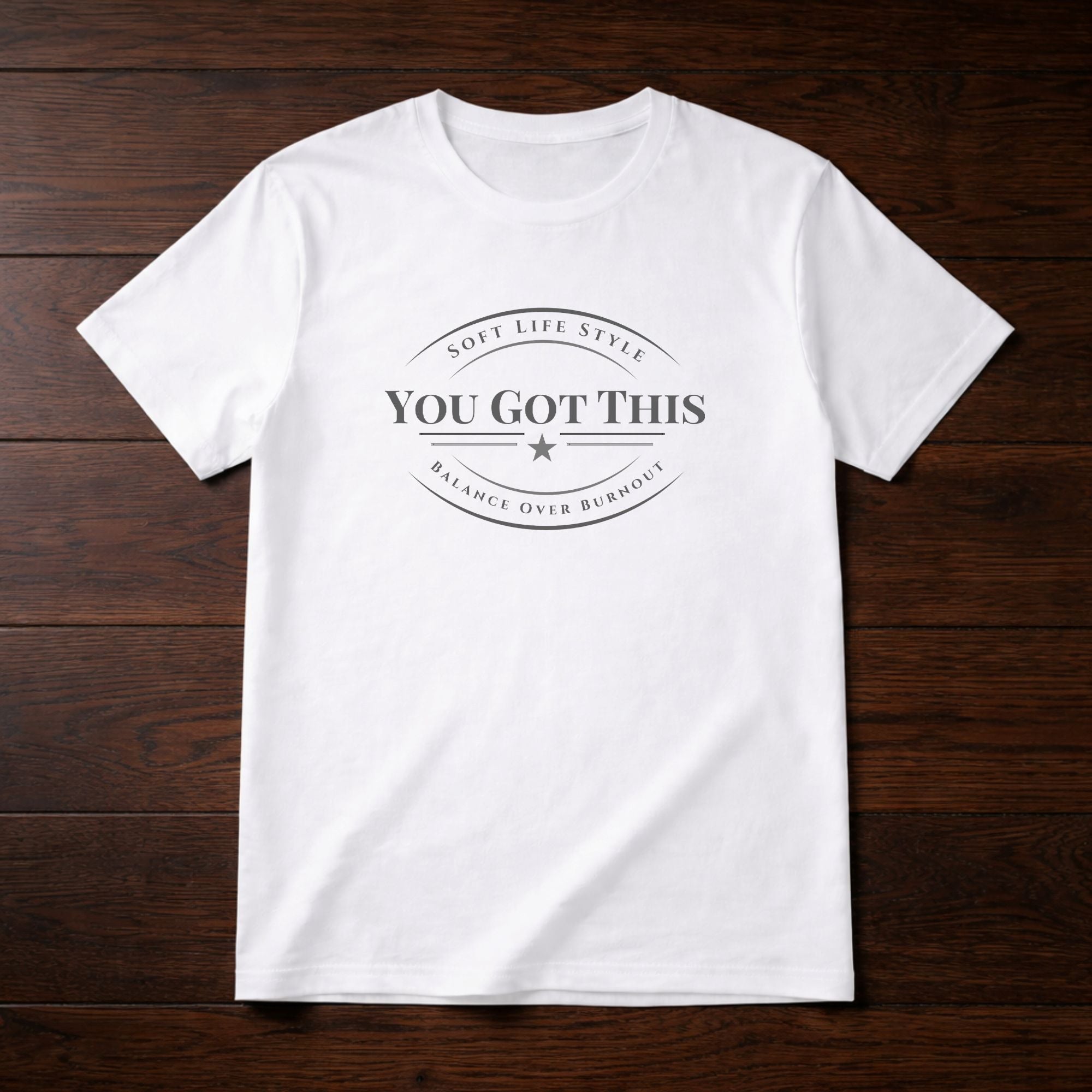 White t-shirt with 'YOU GOT THIS' text on a wooden surface