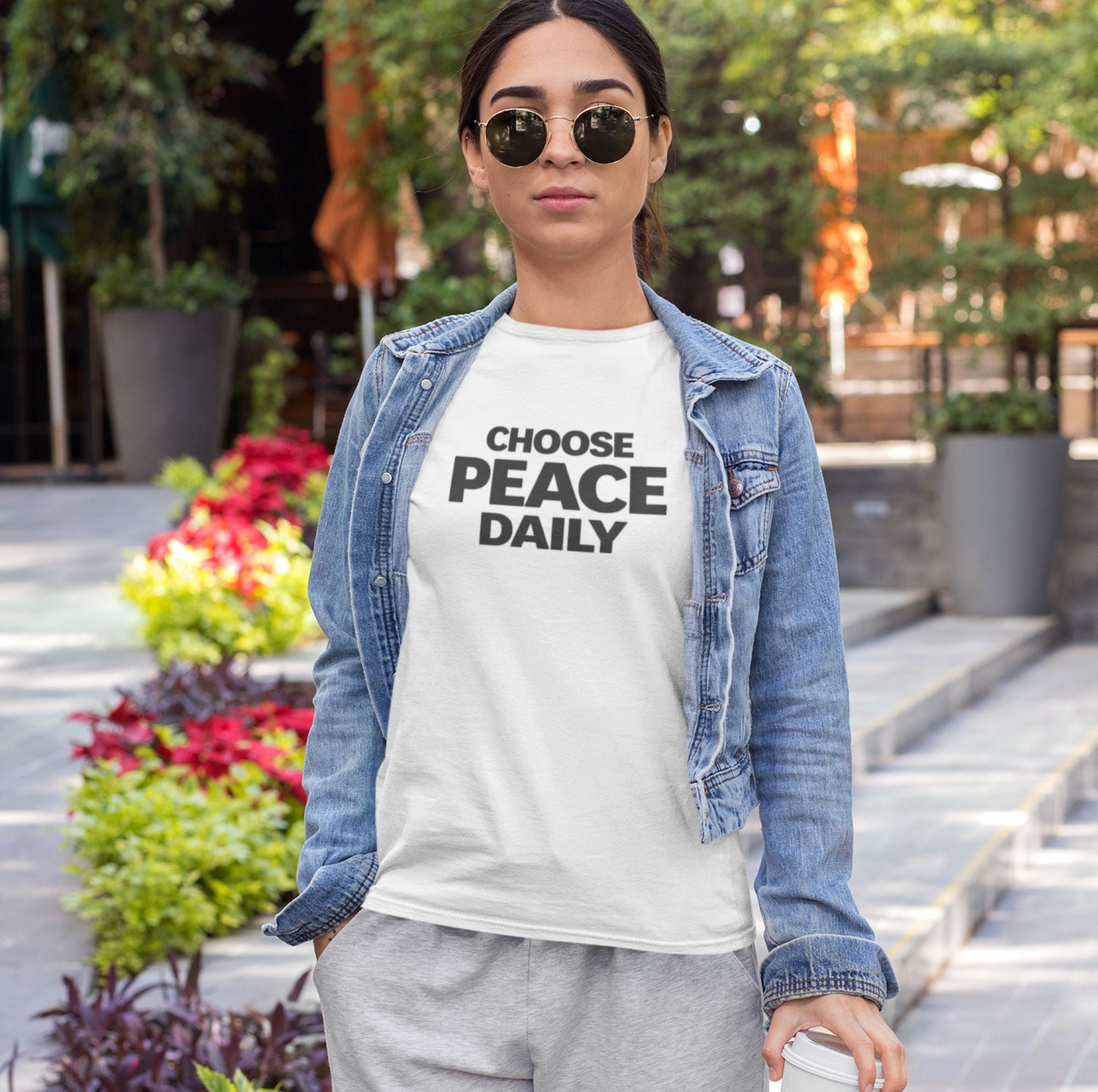 Woman wearing a 'Choose Peace Daily' t-shirt outdoors.