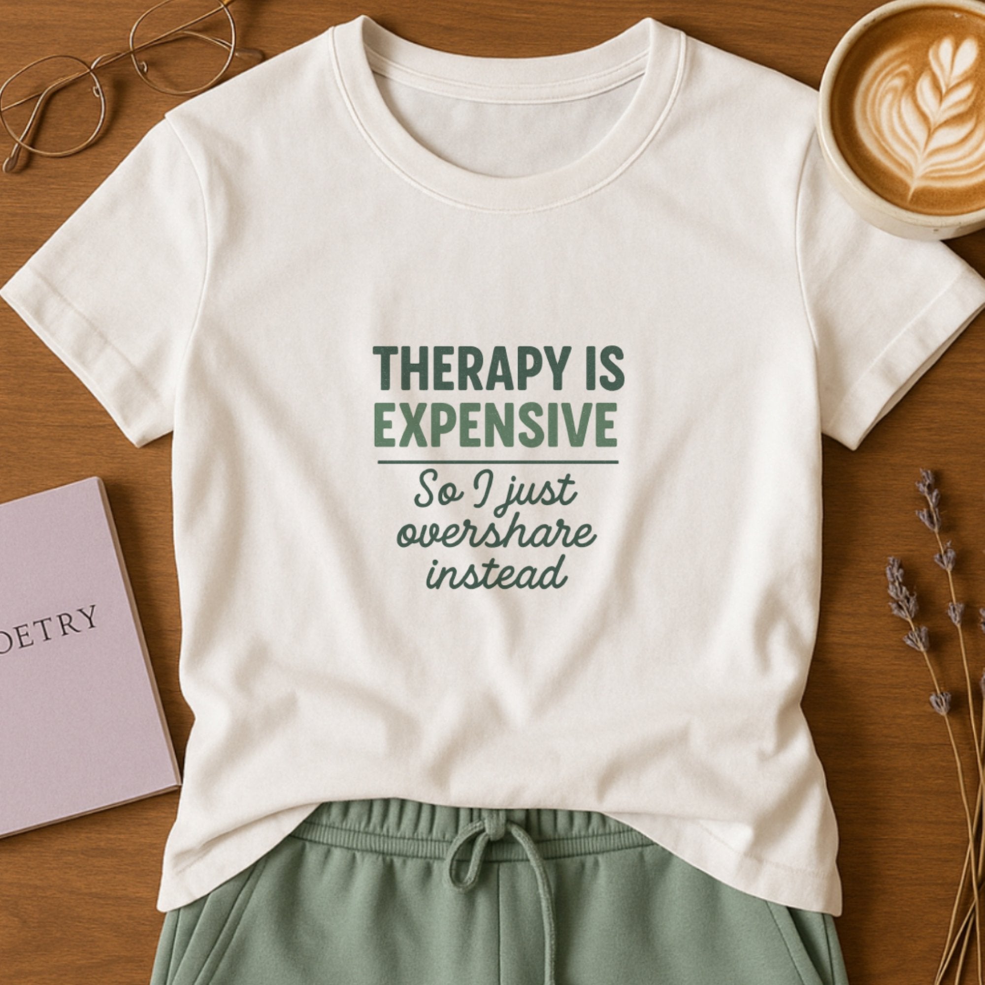 White mental health humor t-shirt with green typography saying “Therapy Is Expensive, So I Just Overshare Instead,” a relatable and playful emotional wellness design