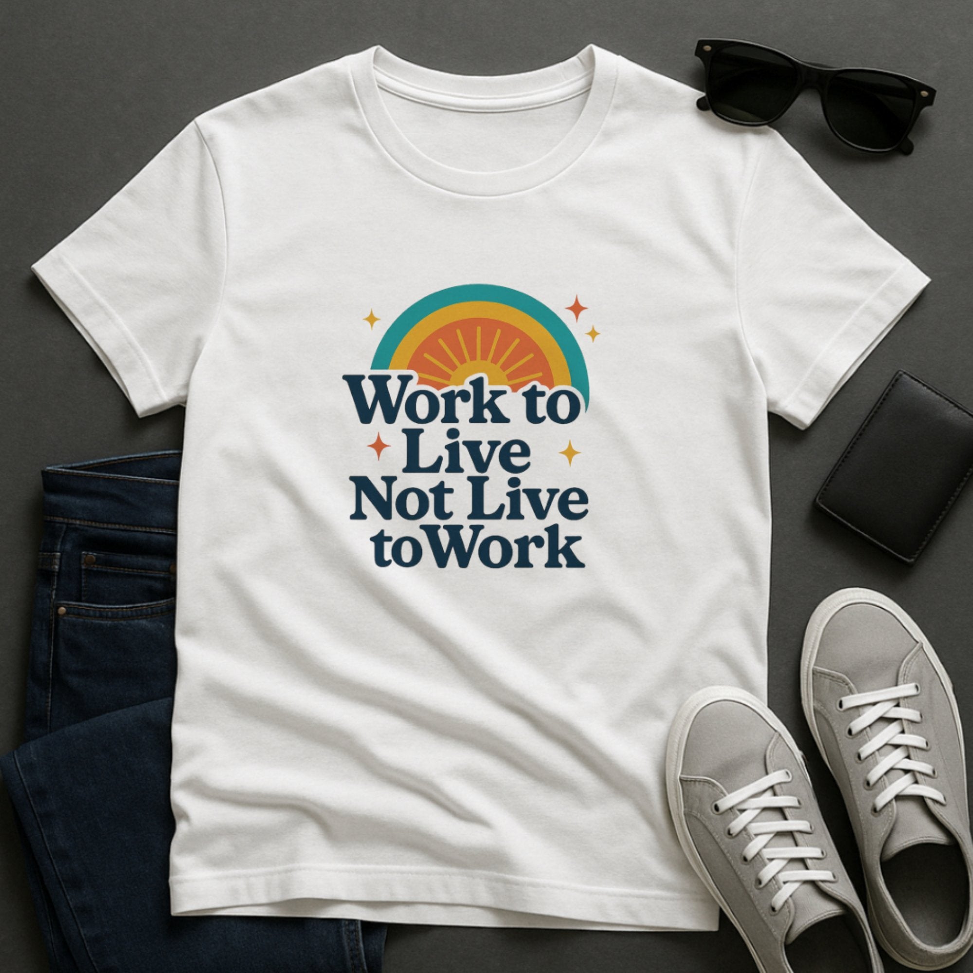 White inspirational t-shirt with bold retro typography and a colorful sunrise graphic saying “Work to Live, Not Live to Work,” promoting balance, boundaries, and mental wellbeing