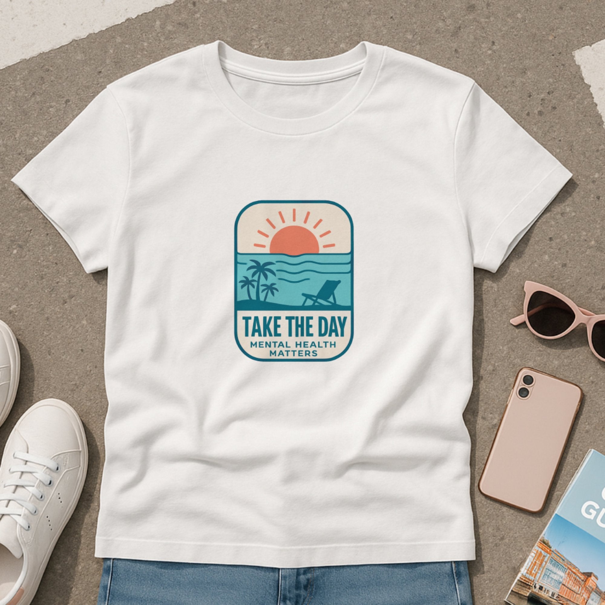 White t-shirt featuring a relaxing beach sunset design with palm trees, a lounge chair, and the message “Take The Day – Mental Health Matters,” encouraging self-care and rest