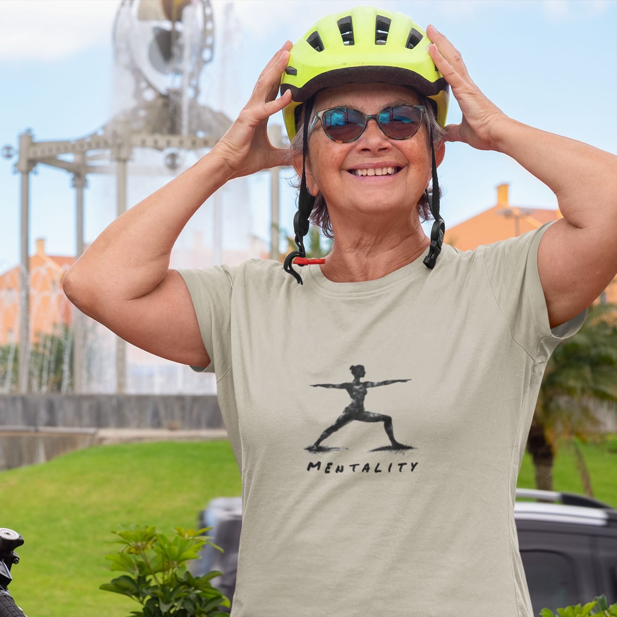 Person wearing a helmet and sunglasses with a t-shirt featuring a graphic and text outdoors.