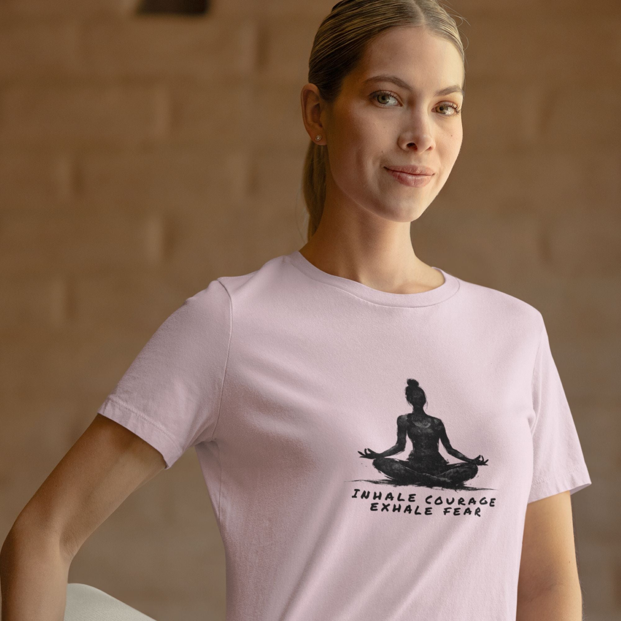 Woman wearing a pink t-shirt with a yoga-themed design and text.