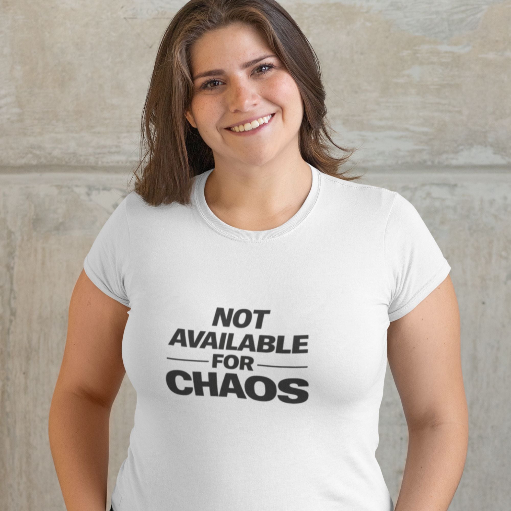Woman wearing a white t-shirt with 'Not Available for Chaos' text against a neutral background